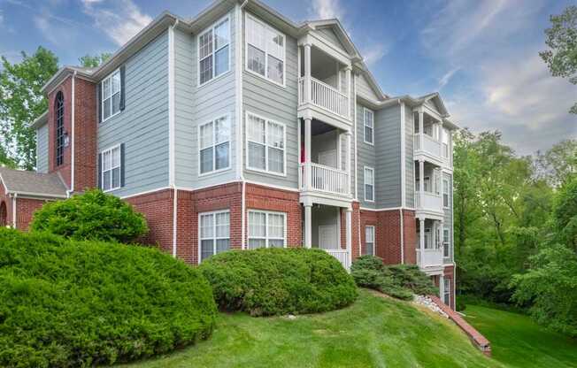 A large apartment building with a green lawn in front.