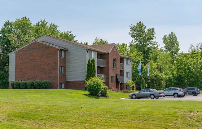 a large brick apartment building with cars parked outside