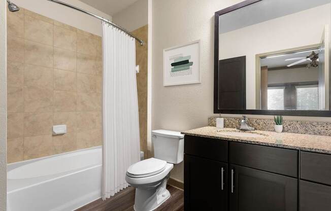 A bathroom with a toilet, sink, and shower.