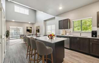 A modern kitchen with a large island and bar stools.
