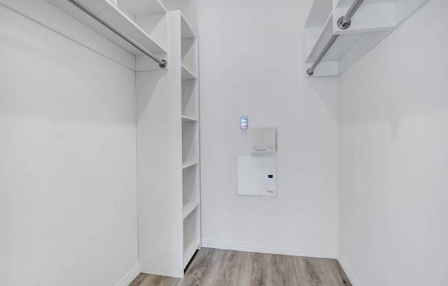 an empty room with white walls and shelves