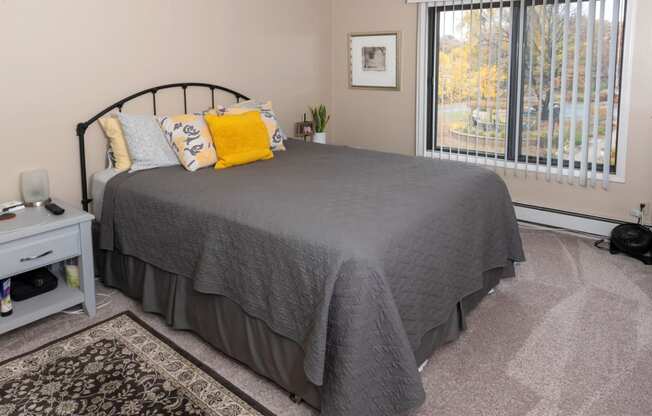 a bedroom with a bed and a large window