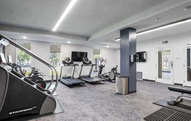 a gym with treadmills and other exercise equipment at The Flats at Riverwoods, Provo, UT