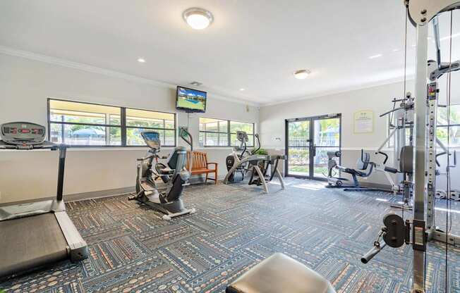 A gym with a variety of equipment including treadmills, weights, and exercise machines.