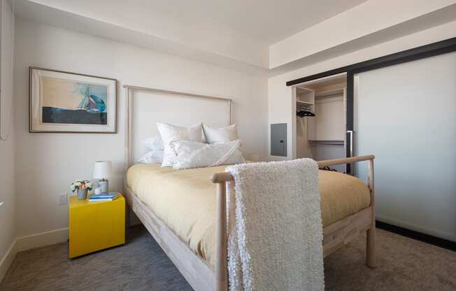 a bedroom with a bed and a yellow nightstand