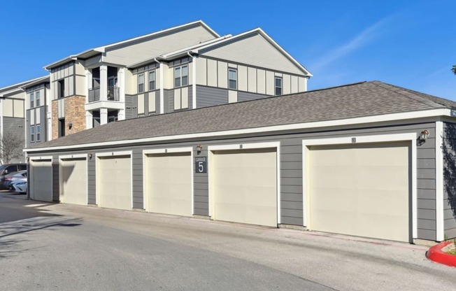 a garage with multiple doors in front of a house