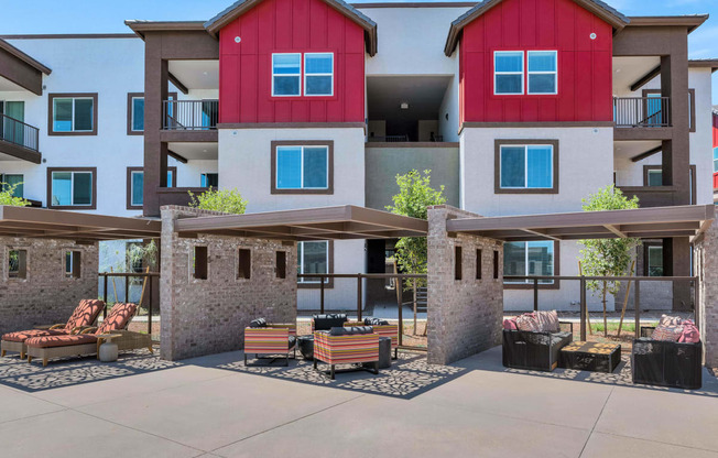 an outdoor patio with benches and tables in front of an apartment buildingat Weylyn Luxury Apartments, Laveen, AZ 85339
