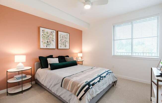 A bedroom with a bed, nightstands, and a window.