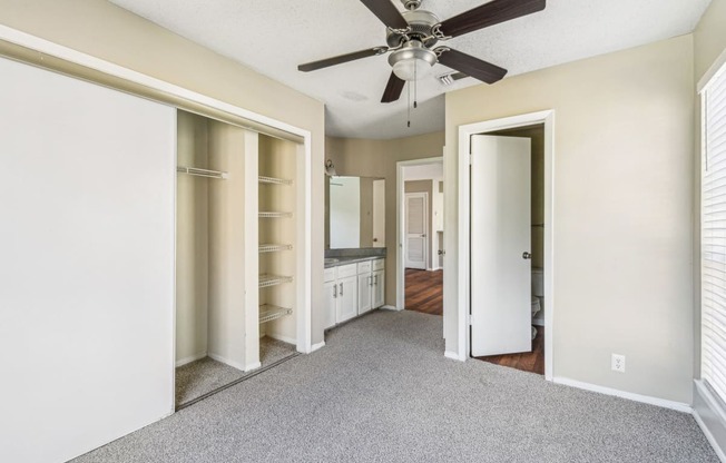 Modern bedroom with carpet and ceiling fan at Bandera Crossing apartments in San Antonio, TX