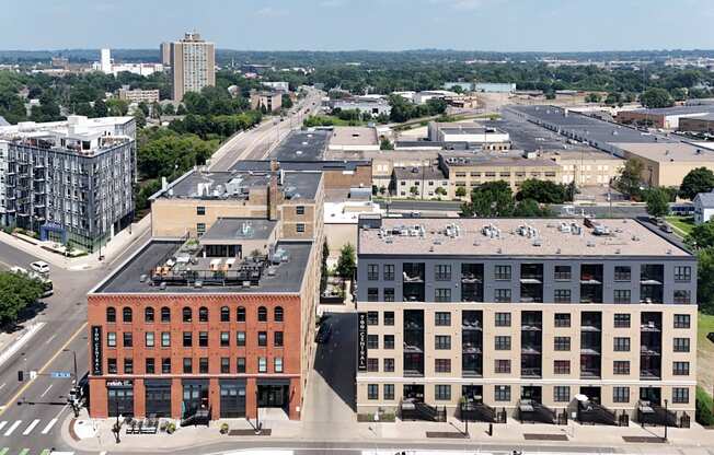 A city street with a red brick building on the left and a white building on the right.