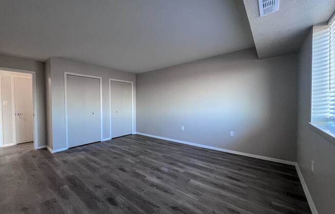 an empty living room with wood floors and white walls