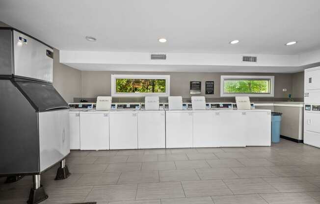 a kitchen with white cabinets and a counter with chairs