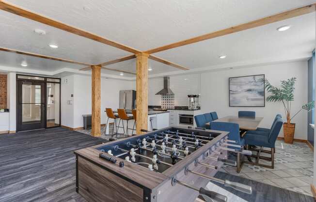 a family room with a foosball table and a kitchen with a dining area