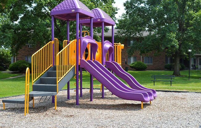 a childrens playground with a purple slide