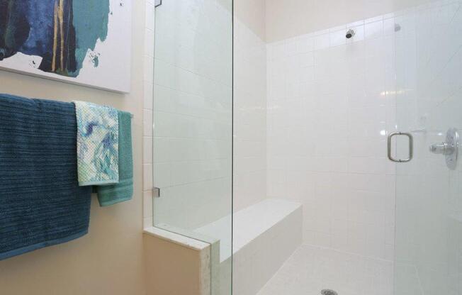 a bathroom with a shower and towels on a towel rack
