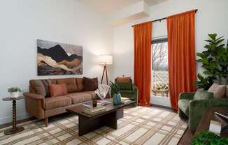 A living room with a brown couch, a coffee table, and a painting on the wall.