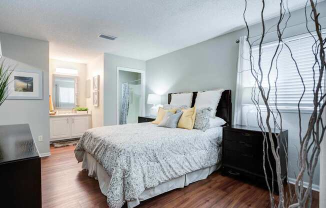 A bedroom with a large bed and a plant.