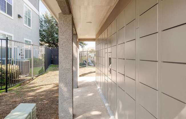 a walkway leading to a building with a fence and a bench