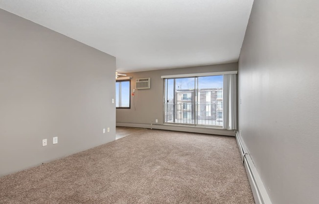 the living room of an empty house with a large window. Roseville, MN Rosedale Estates