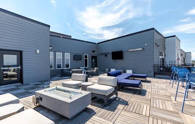 a patio with couches and chairs and a fire pit