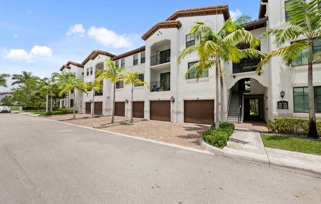a large white building with palm trees in front of it