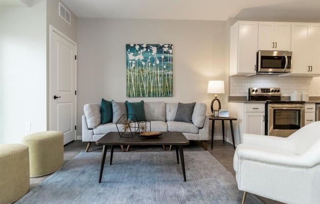 Living room with couch and coffee table open to the kitchen