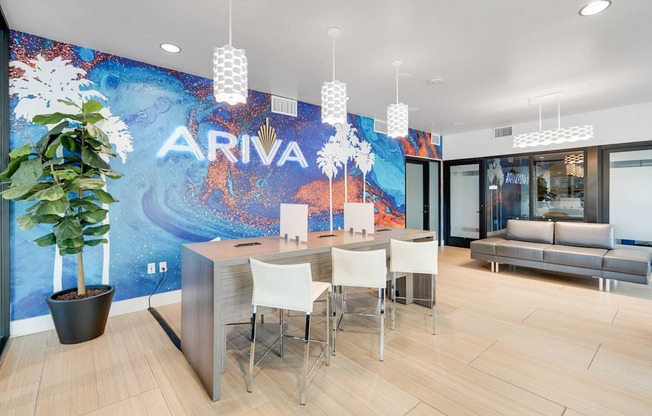 A white desk with chairs in front of a wall with the word ARIVA on it.