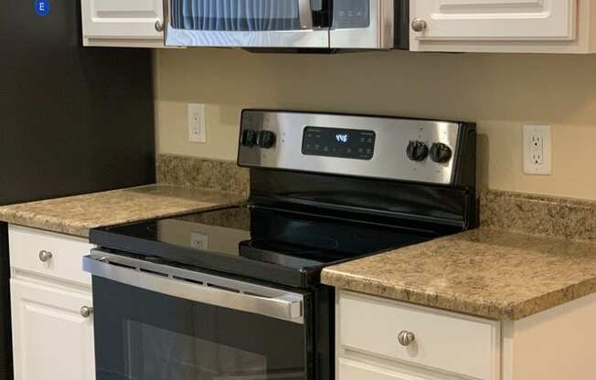 Kitchen with White Cabinets and Black Appliances at Arcadia Townhomes, Federal Way, WA, 98023