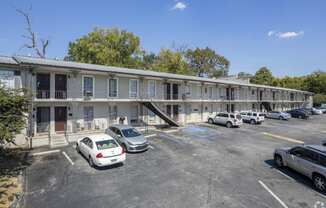 a motel building with cars parked in front of it