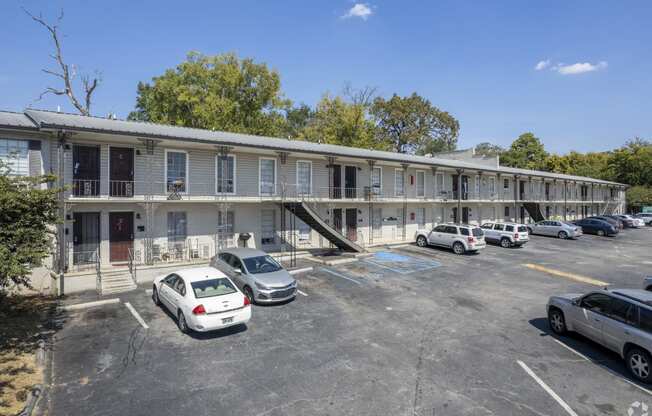 a motel building with cars parked in front of it