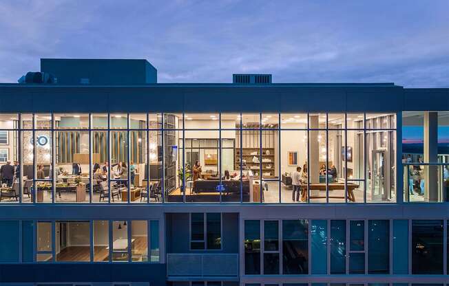 a view of a building with glass windows at dusk