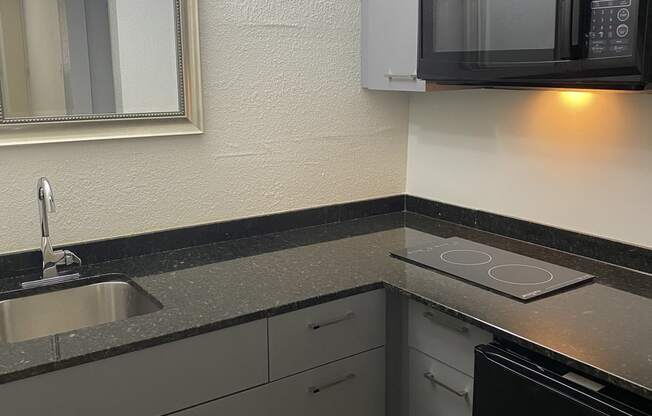 a kitchen with a sink and a microwave at Colonial Apartments, Orlando Florida