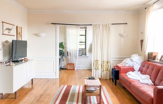 a living room with red furniture and a striped rug