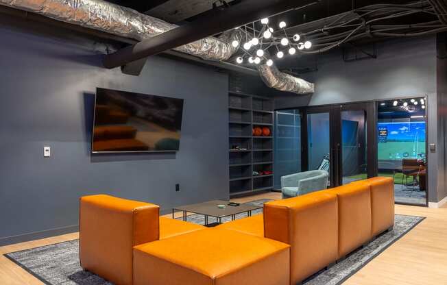 a living room with orange couches and a television