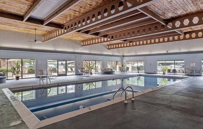 a large indoor swimming pool with a wooden ceiling