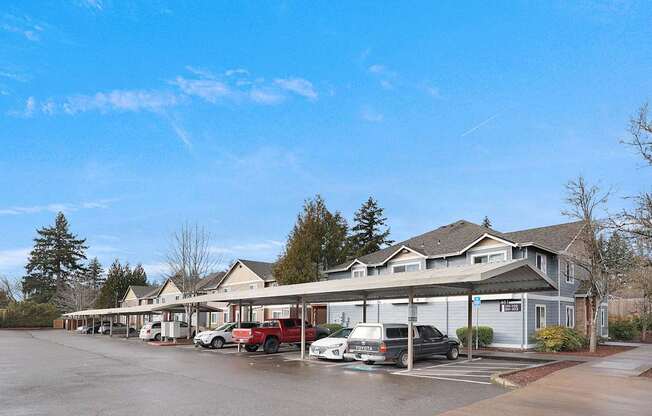 A parking lot with cars and a building in the background.
