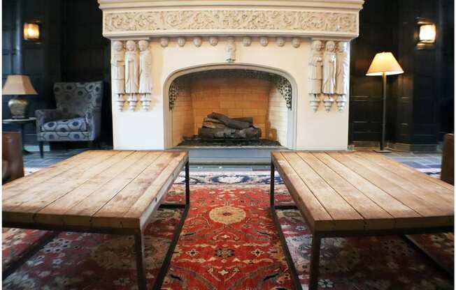 a couple of wooden tables in front of a fireplace