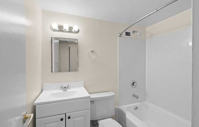 a white bathroom with a white sink and toilet and a tub