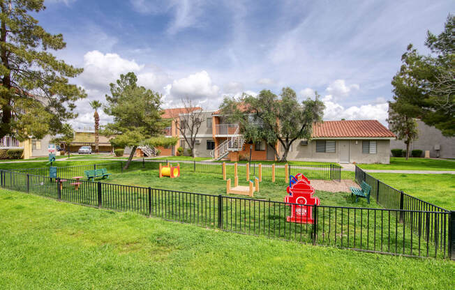 a playground with a fire hydrant in the middle of a grassy area