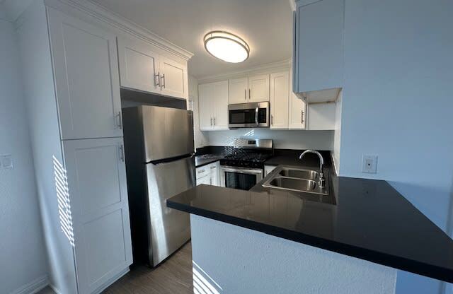 a kitchen with a stainless steel refrigerator and a sink