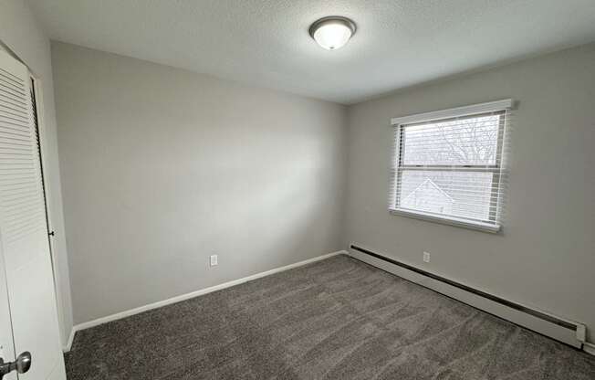 an empty room with carpet and a window