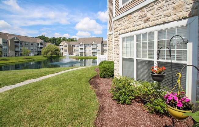 This is a picture of a pond with a fountain and  building exteriors at Nantucket Apartments, in Loveland, OH.