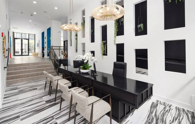 a dining room with a long black table and chairs