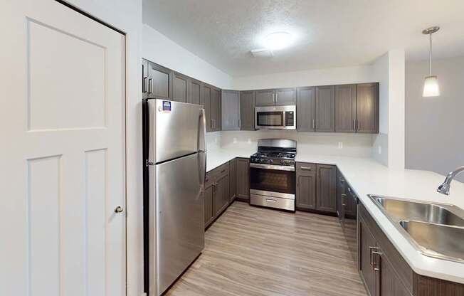 A modern kitchen with stainless steel appliances at Meadowbrooke Apartment Homes in Kentwood, MI 49512