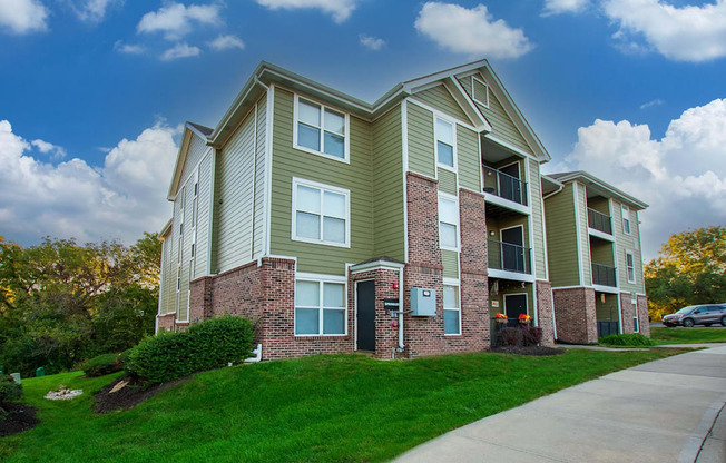 A two-story apartment building with a green and beige exterior.