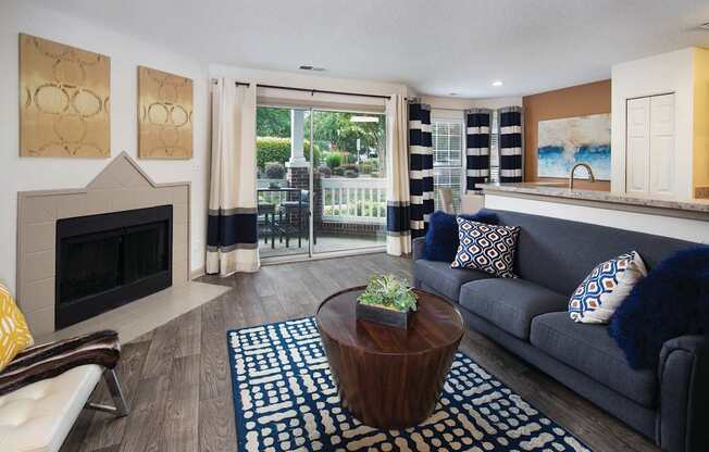 A living room with a fireplace and a blue couch.
