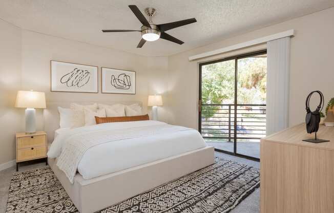 a bedroom with a bed and a ceiling fan