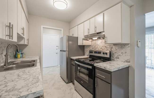 a kitchen with stainless steel appliances and marble counter tops