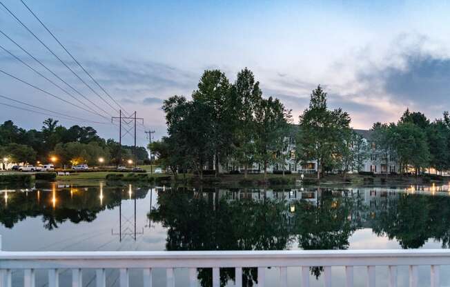 a view of a lake with a white railing in the foreground