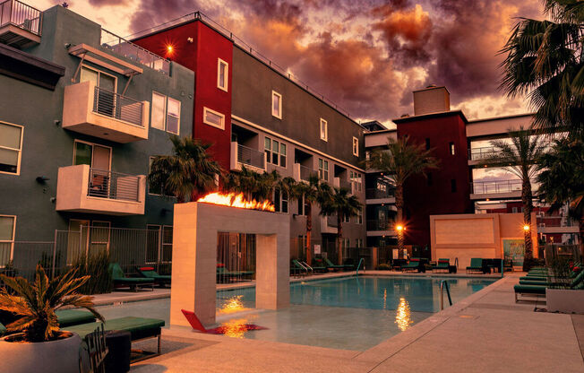 A pool area with a fire pit in the middle of it.